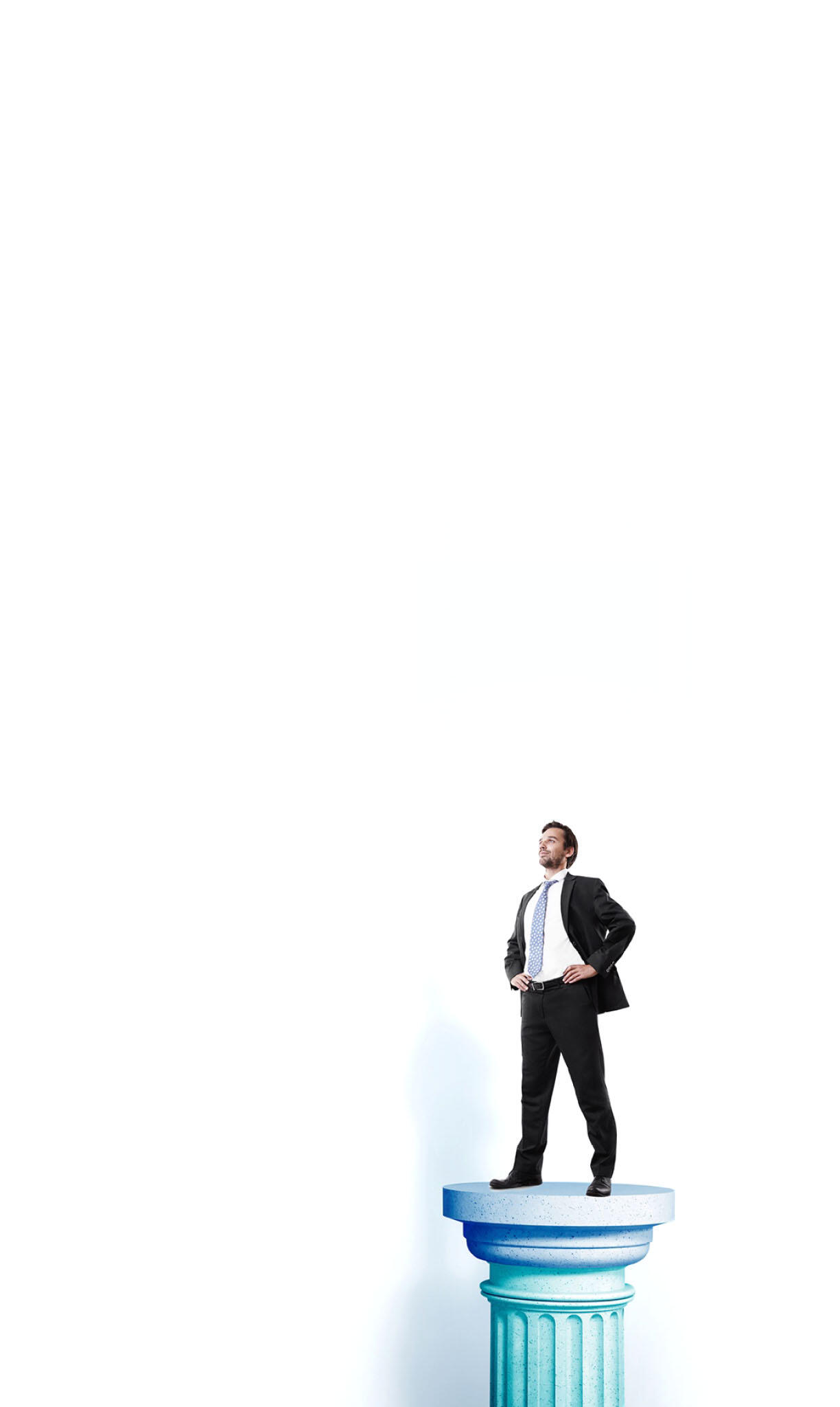 A man in a suit confidently stands atop a pillar, showcasing a poised and professional demeanor.