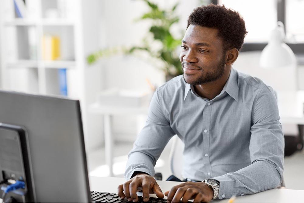 Confident man in business casual attire working on his laptop at home