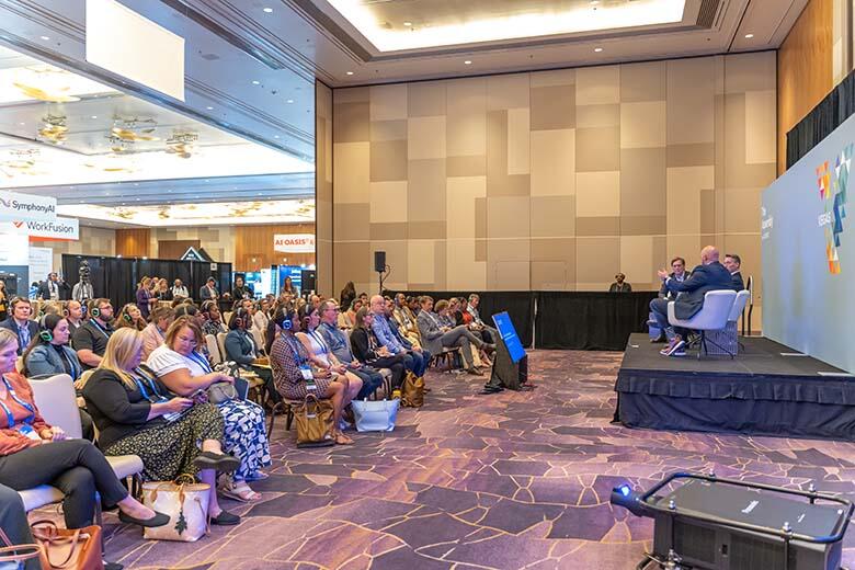 A packed conference room showcasing a large audience engaged in various discussions and activities.