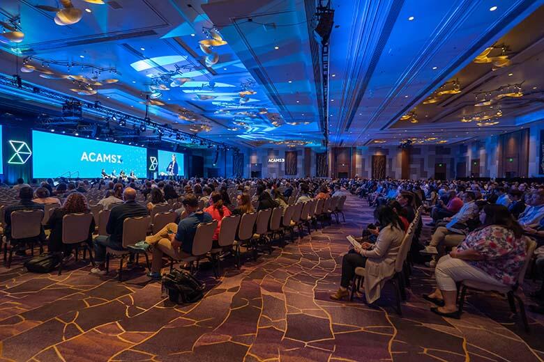 A bustling conference room filled with a diverse crowd of people participating in a professional event.