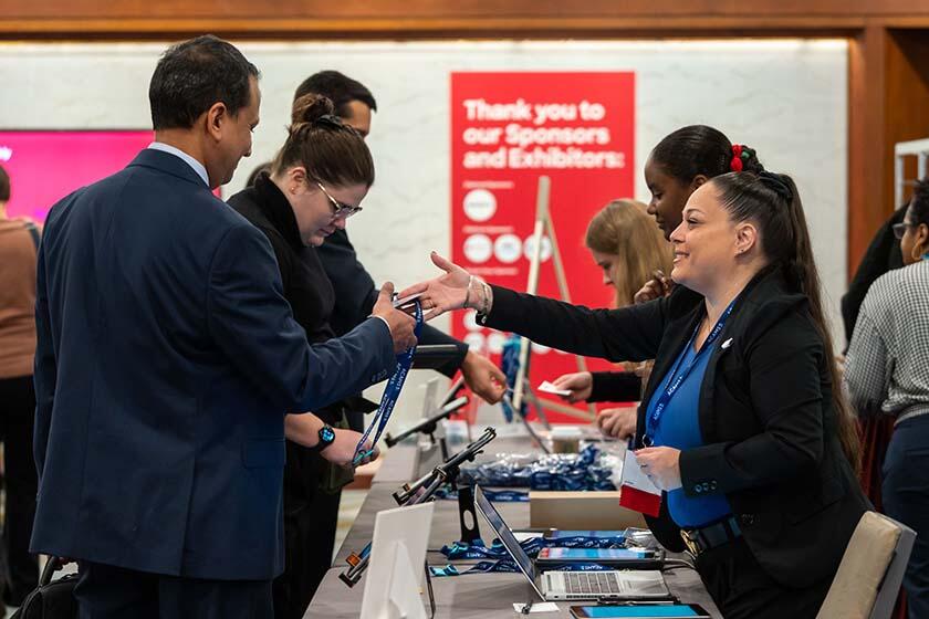 A man and woman shake hands at a job fair, symbolizing a professional connection and potential employment opportunity.