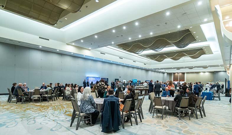 A spacious room featuring multiple tables and chairs arranged for gatherings or meetings.