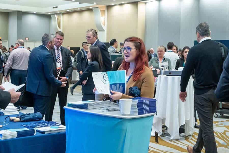 A diverse group of individuals networking at a job fair inside a spacious convention center, showcasing various career opportunities.