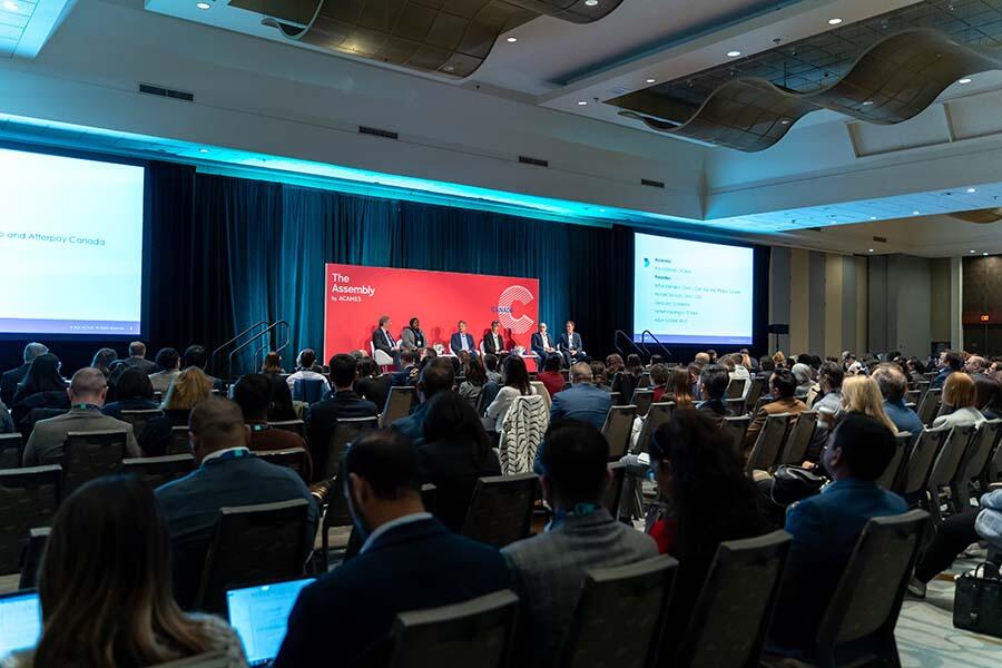 A diverse group of individuals seated in chairs, attentively participating in a conference setting.