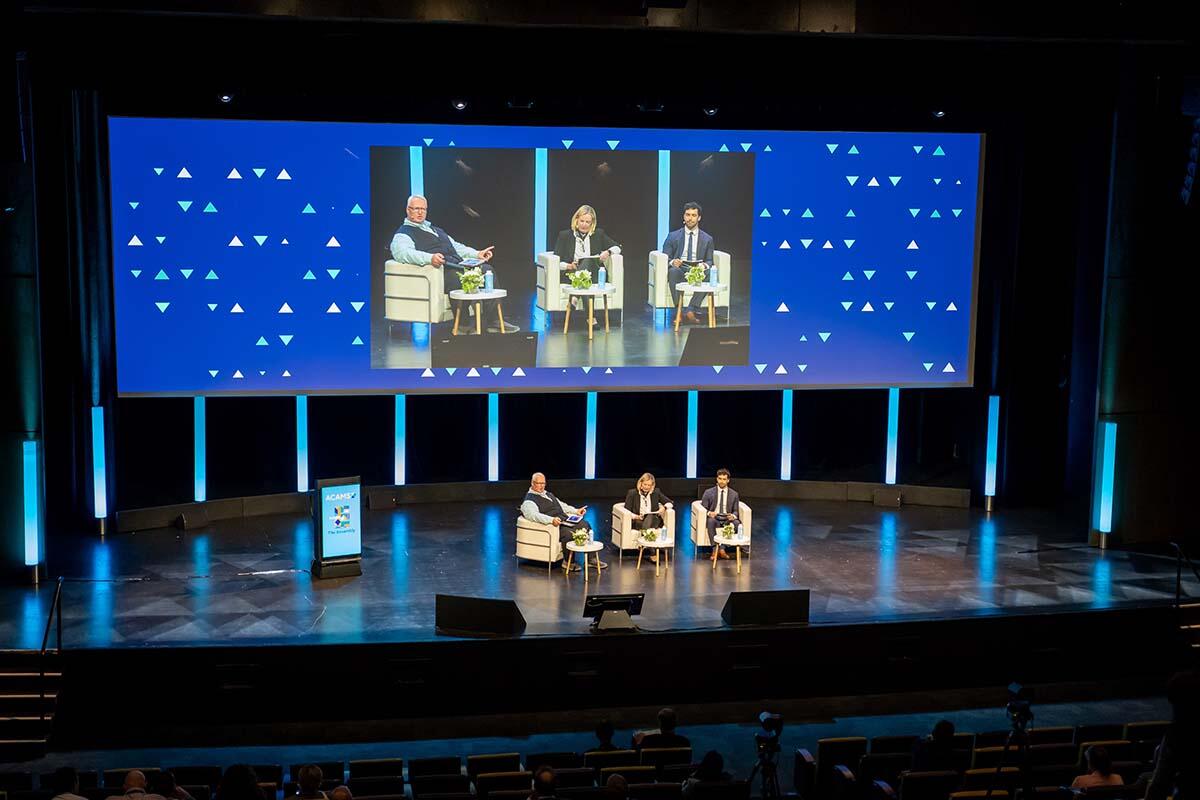 Three expert speakers talking in the ACAMS Europe Assembly auditorium