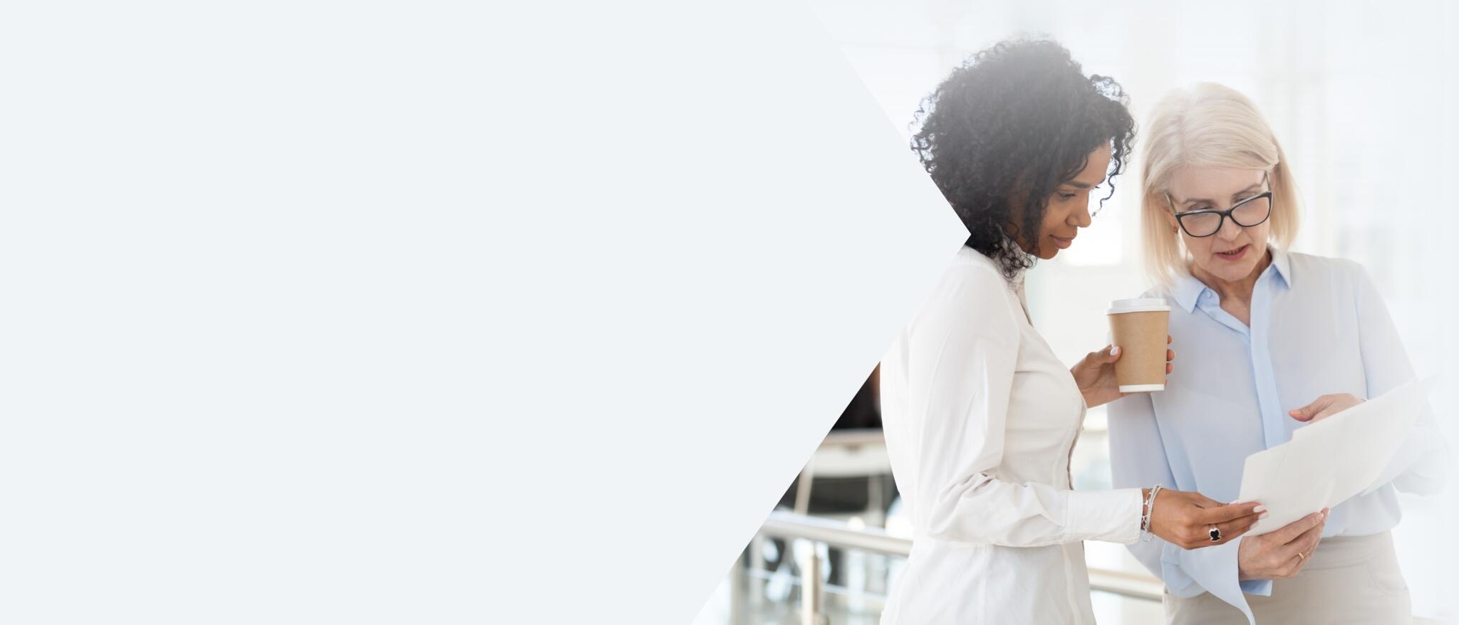 Two business women look over documents together